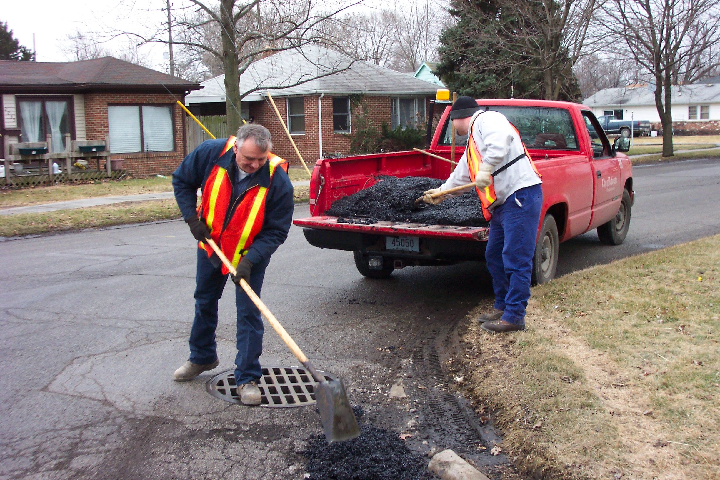 Street Department crew members filling a pothole.