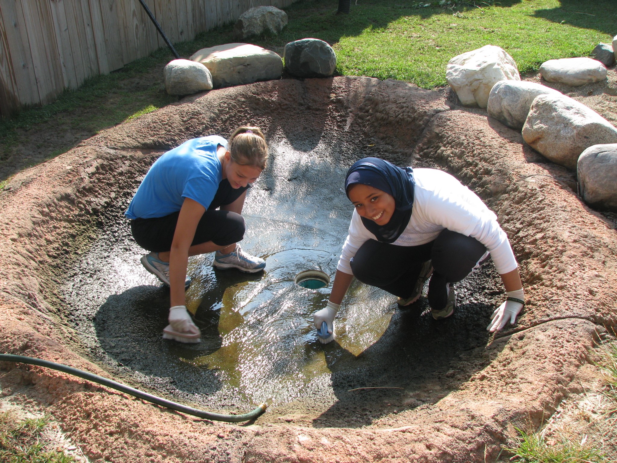 Hafsa and Bre scrubbing the wallaby pool.JPG