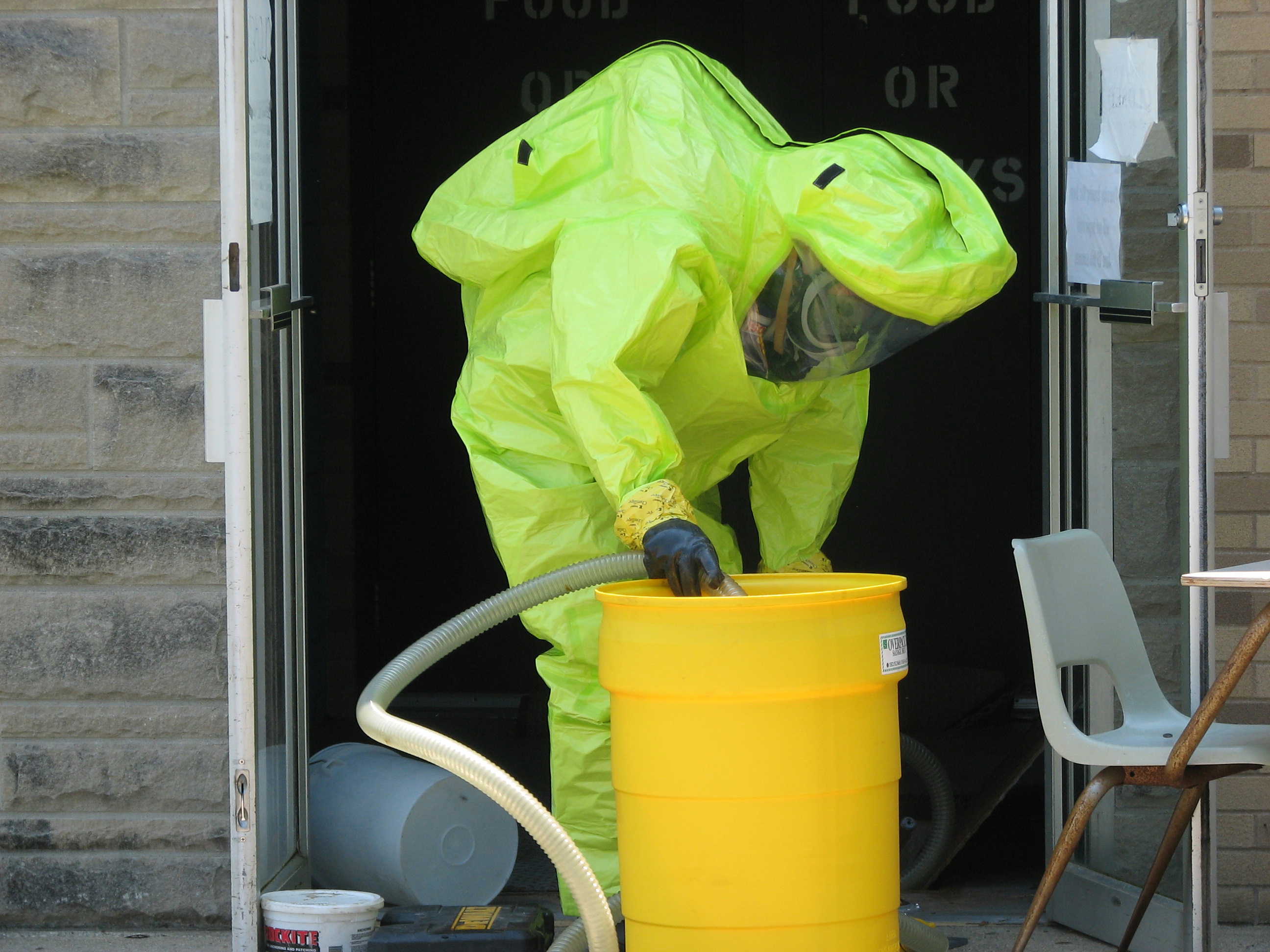 Carroll Incident - HazMat Team Member in HazMat Suit with a hose and a barrel
